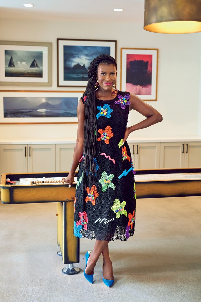 Woman standing in front of pool table, wearing floral dress